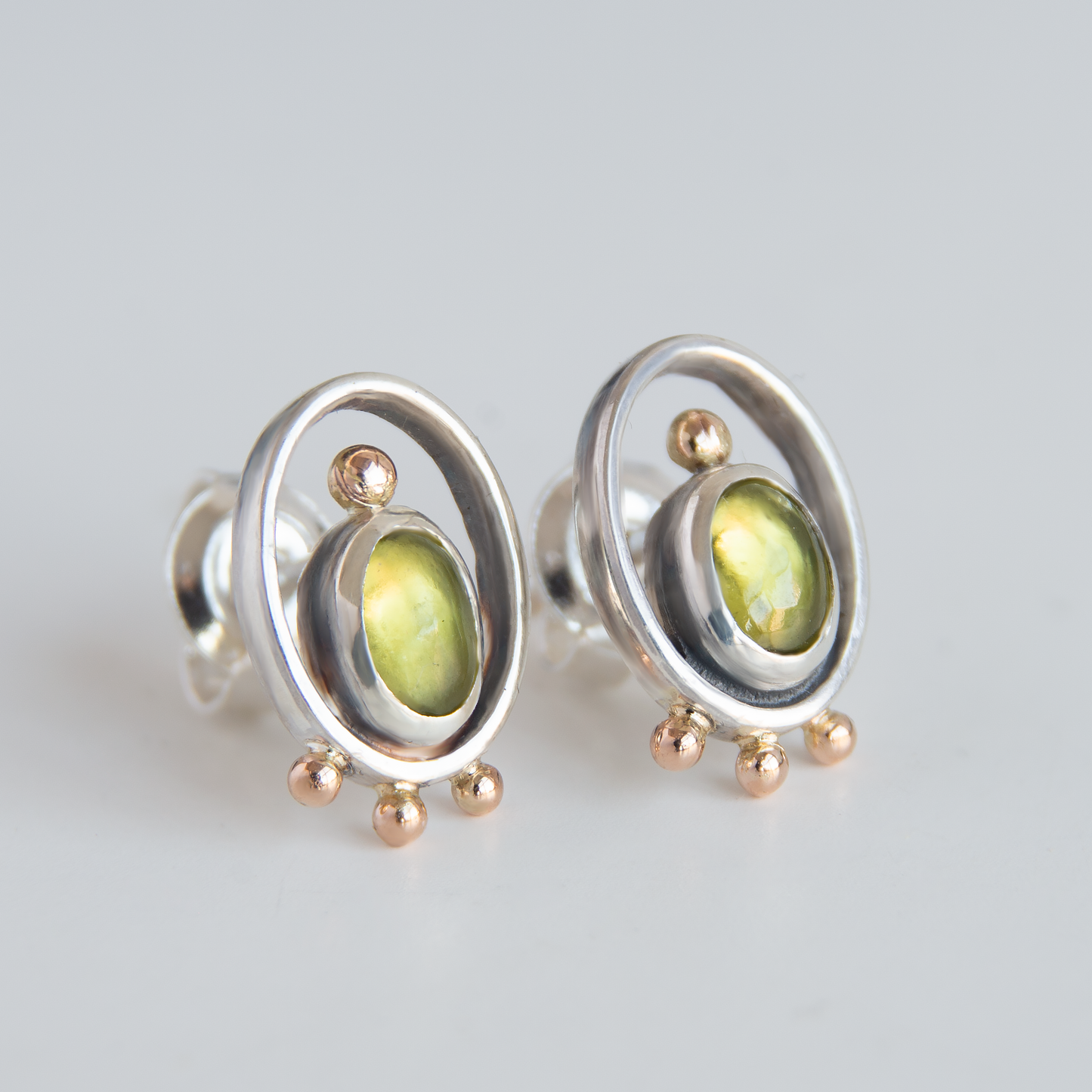 Oval Frame Earrings With Gold Beads And Olivine Stones