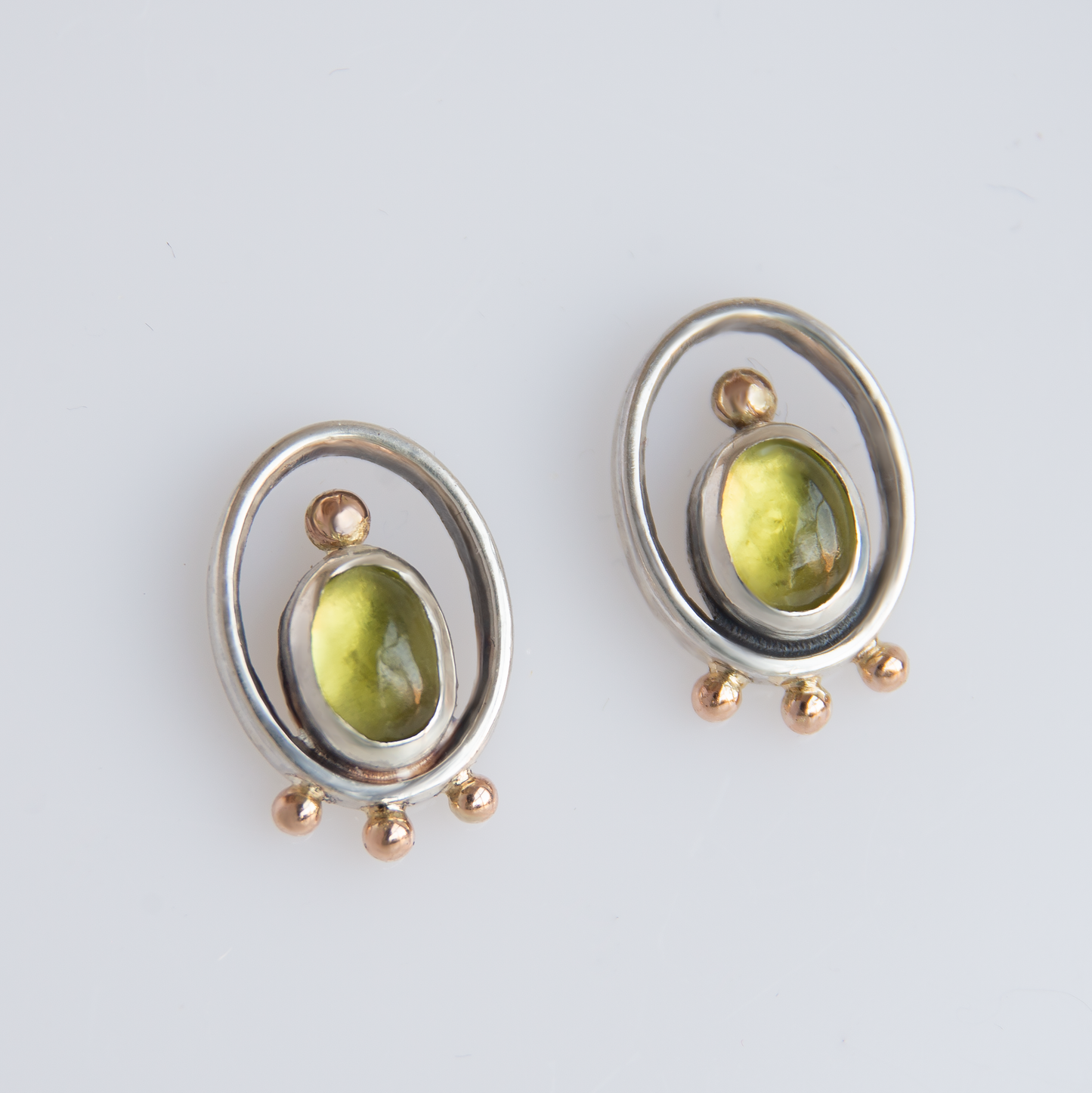 Oval Frame Earrings With Gold Beads And Olivine Stones